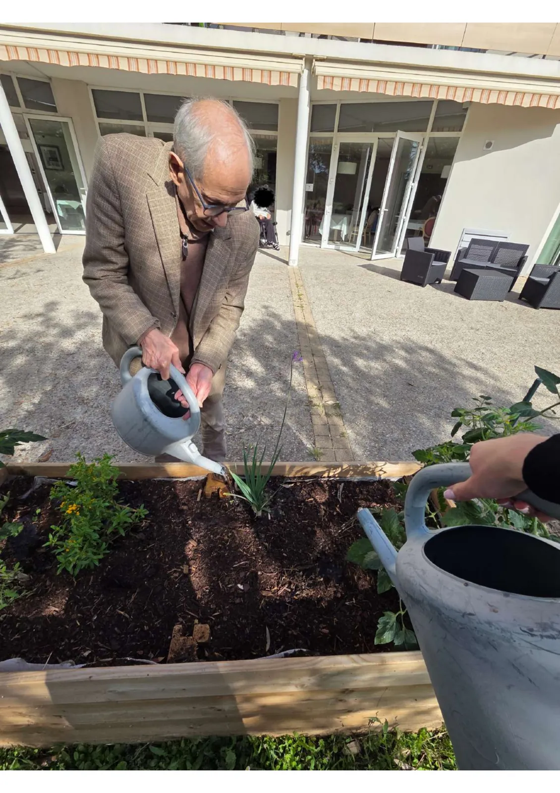 Participation des résidents à l’arrosage du jardin